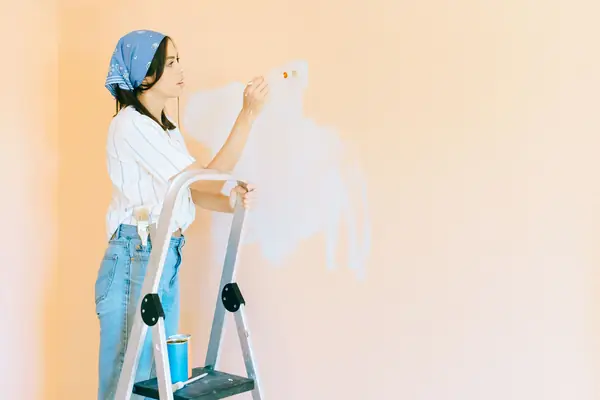 Interior painting in Chicago: painter on a stepladder rolling a wall